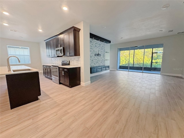 2164 Crosston Cir, Orlando, FL 32824 - kitchen with stainless steel appliances, open floor plan, a sink, dark brown cabinets, and recessed lighting