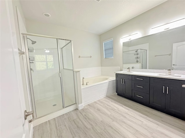 2164 Crosston Cir, Orlando, FL 32824 - bathroom with a bath, a shower stall, double vanity, and wood finished floors
