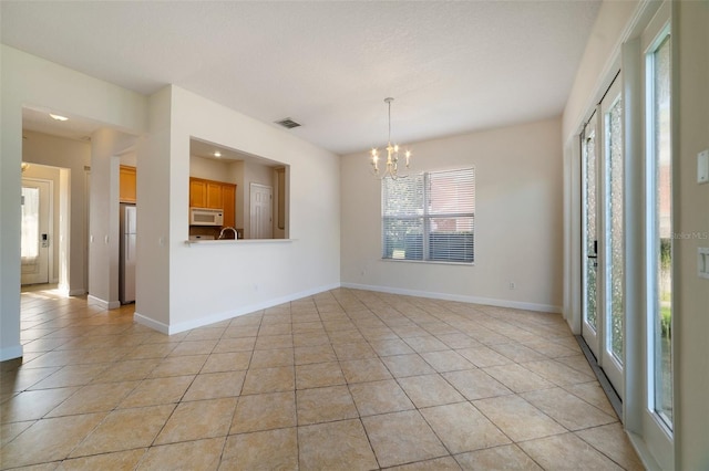 7740 Linkside Loop, Reunion, FL 34747 - spare room featuring light tile patterned floors, a chandelier, and baseboards
