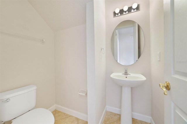 7740 Linkside Loop, Reunion, FL 34747 - half bathroom with toilet, vaulted ceiling, tile patterned floors, baseboards, and a sink