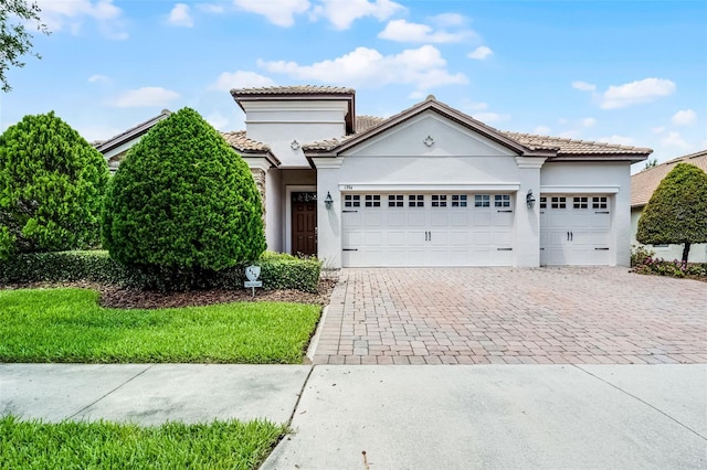 1394 Palmetto Dunes St, Champions Gate, FL 33896 - mediterranean / spanish-style house with a garage, decorative driveway, stucco siding, and a tile roof
