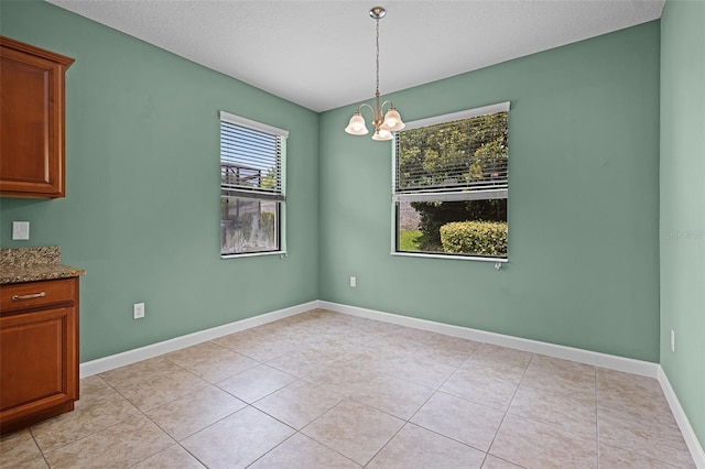 1394 Palmetto Dunes St, Champions Gate, FL 33896 - unfurnished dining area with a chandelier, light tile patterned floors, baseboards, and a textured ceiling