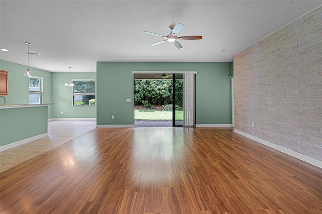 1394 Palmetto Dunes St, Champions Gate, FL 33896 - unfurnished room featuring a ceiling fan, a textured ceiling, wood finished floors, and baseboards