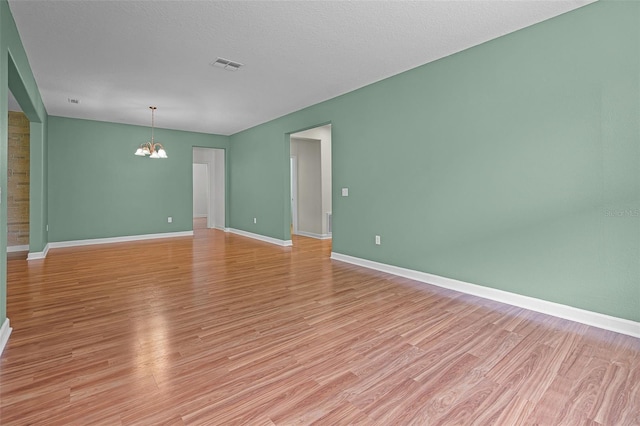 1394 Palmetto Dunes St, Champions Gate, FL 33896 - empty room with a chandelier, light wood-type flooring, and baseboards