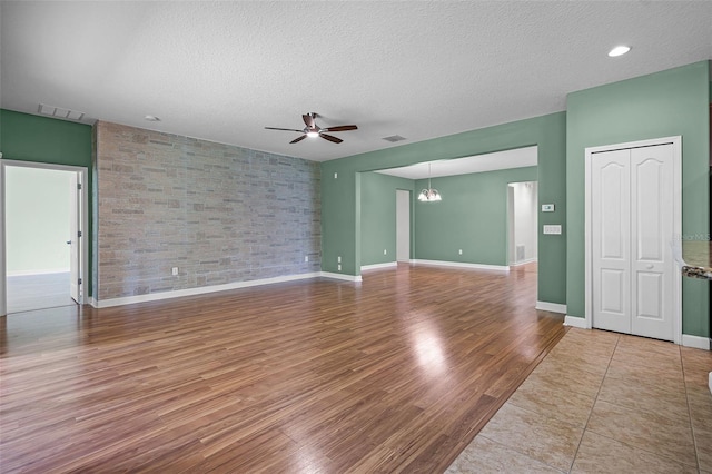 1394 Palmetto Dunes St, Champions Gate, FL 33896 - empty room featuring a ceiling fan, wood finished floors, a textured ceiling, and baseboards