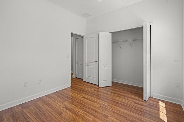 1394 Palmetto Dunes St, Champions Gate, FL 33896 - unfurnished bedroom featuring wood finished floors, baseboards, and a closet