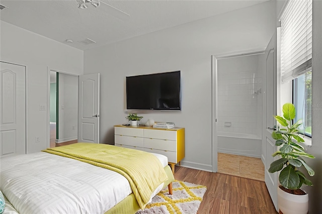 1394 Palmetto Dunes St, Champions Gate, FL 33896 - bedroom with ensuite bath, wood finished floors, and baseboards