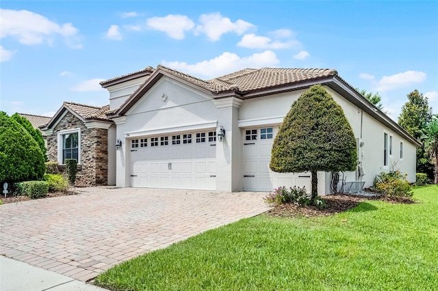 1394 Palmetto Dunes St, Champions Gate, FL 33896 - view of front of property with a tiled roof, a garage, decorative driveway, stucco siding, and a front lawn