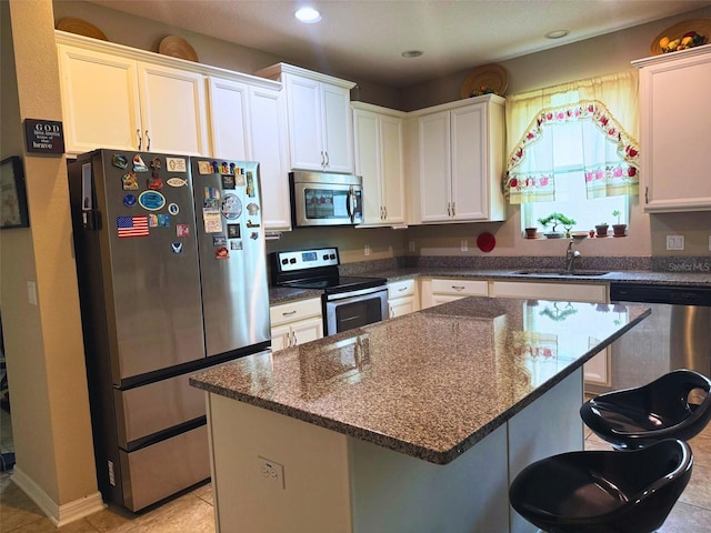3333 Sagebrush St, Harmony, FL 34773 - kitchen with stainless steel appliances, a sink, a kitchen breakfast bar, dark stone counters, and a kitchen island