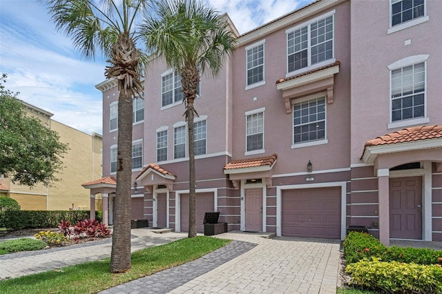 5038 Tideview Cir Unit 21, Orlando, FL 32819 - townhome / multi-family property with stucco siding, decorative driveway, an attached garage, and a tile roof