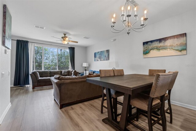 5038 Tideview Cir Unit 21, Orlando, FL 32819 - dining area featuring light wood-style floors, baseboards, a chandelier, and ceiling fan