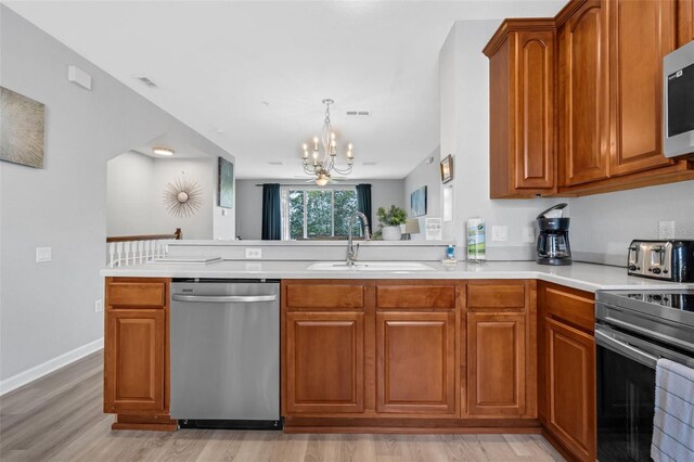 5038 Tideview Cir Unit 21, Orlando, FL 32819 - kitchen with stainless steel appliances, a sink, a chandelier, and brown cabinets