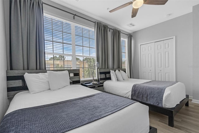 5038 Tideview Cir Unit 21, Orlando, FL 32819 - bedroom featuring wood finished floors, a closet, multiple windows, and ceiling fan