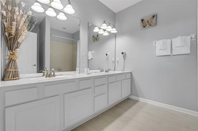 5038 Tideview Cir Unit 21, Orlando, FL 32819 - bathroom featuring double vanity, a shower, and baseboards
