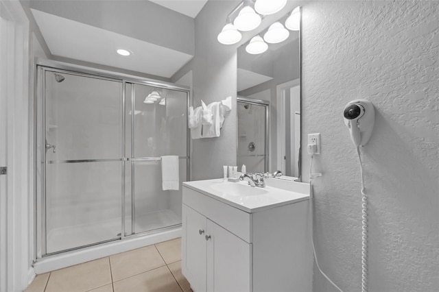 5038 Tideview Cir Unit 21, Orlando, FL 32819 - full bathroom with a textured wall, tile patterned flooring, a shower stall, and vanity