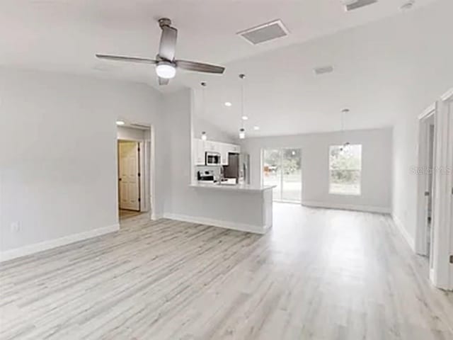 14512 SW 25th Ln, Ocala, FL 34481 - unfurnished living room with lofted ceiling, baseboards, light wood-style flooring, and ceiling fan