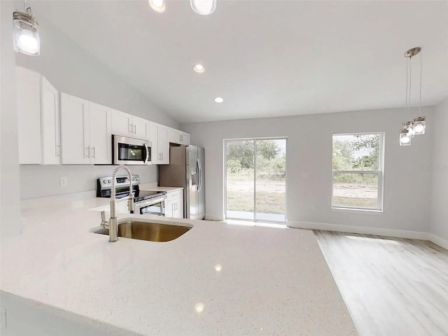 14512 SW 25th Ln, Ocala, FL 34481 - kitchen featuring appliances with stainless steel finishes, recessed lighting, pendant lighting, white cabinets, and a sink