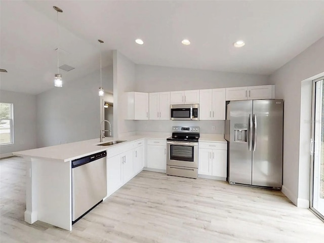 14512 SW 25th Ln, Ocala, FL 34481 - kitchen featuring stainless steel appliances, a sink, vaulted ceiling, light countertops, and a peninsula