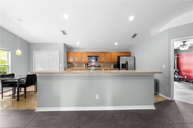4726 Ashurst St, Kissimmee, FL 34758 - kitchen with appliances with stainless steel finishes, lofted ceiling, light countertops, decorative backsplash, and recessed lighting
