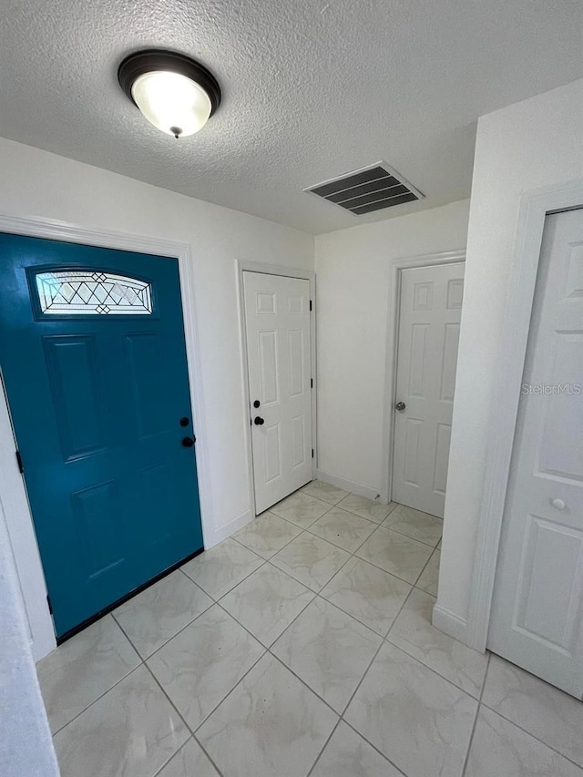 198 N Lake Ct, Kissimmee, FL 34743 - entryway featuring light marble finish flooring and a textured ceiling