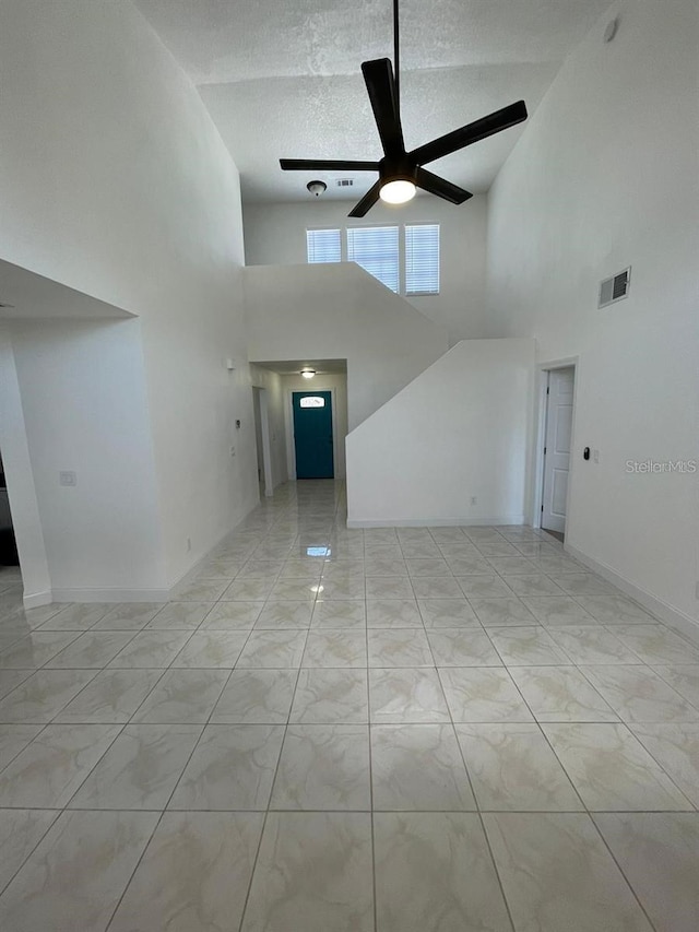 198 N Lake Ct, Kissimmee, FL 34743 - unfurnished living room with high vaulted ceiling, a ceiling fan, marble look tiles, and a textured ceiling