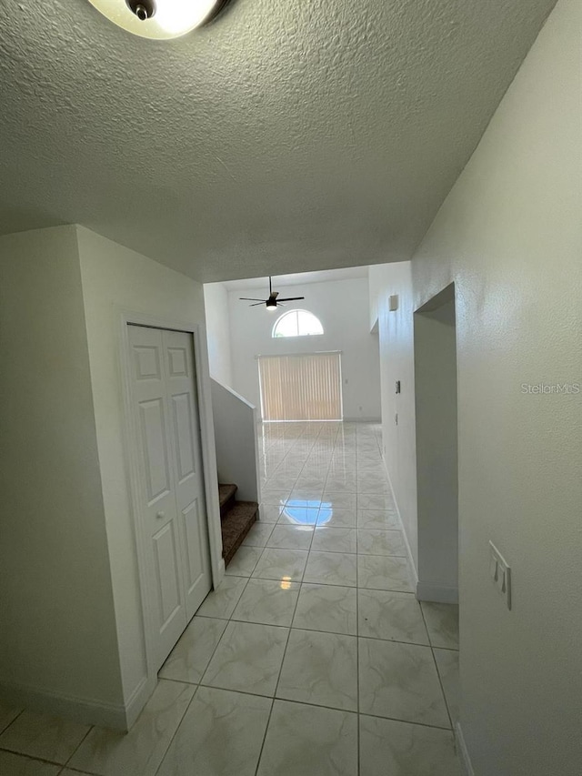 198 N Lake Ct, Kissimmee, FL 34743 - hall with light marble finish floors, stairway, baseboards, and a textured ceiling