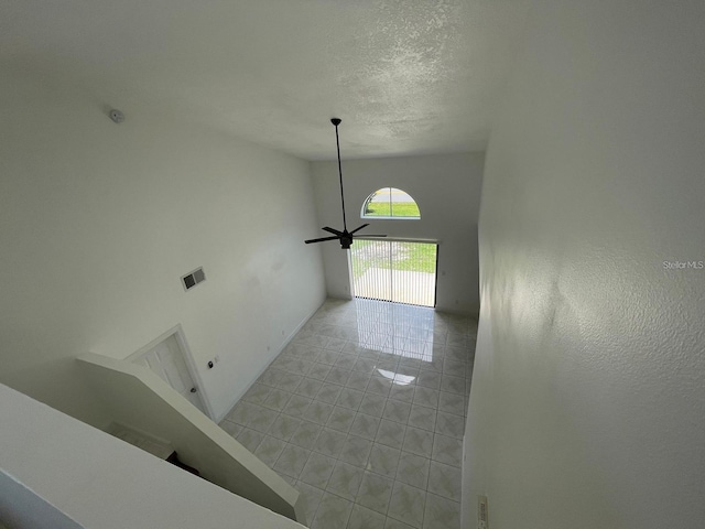 198 N Lake Ct, Kissimmee, FL 34743 - unfurnished living room with a textured ceiling, ceiling fan, light tile patterned floors, and baseboards