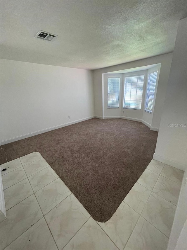 198 N Lake Ct, Kissimmee, FL 34743 - spare room with carpet flooring, marble finish floors, baseboards, and a textured ceiling