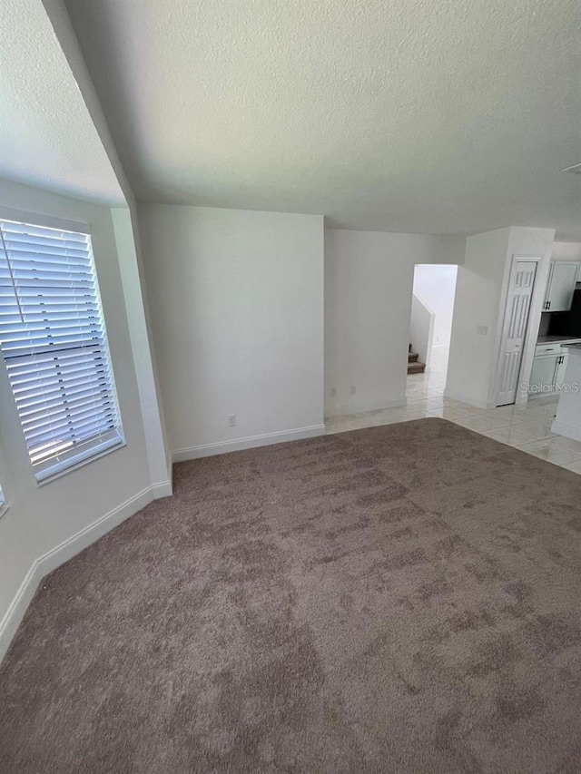 198 N Lake Ct, Kissimmee, FL 34743 - unfurnished room featuring a textured ceiling, light colored carpet, stairway, and baseboards