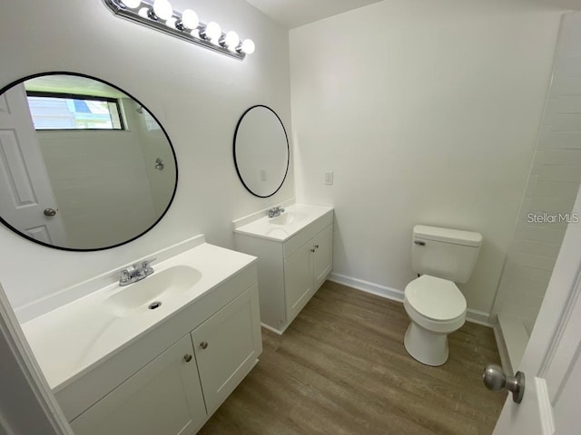 198 N Lake Ct, Kissimmee, FL 34743 - full bathroom featuring wood finished floors, two vanities, toilet, baseboards, and tiled shower