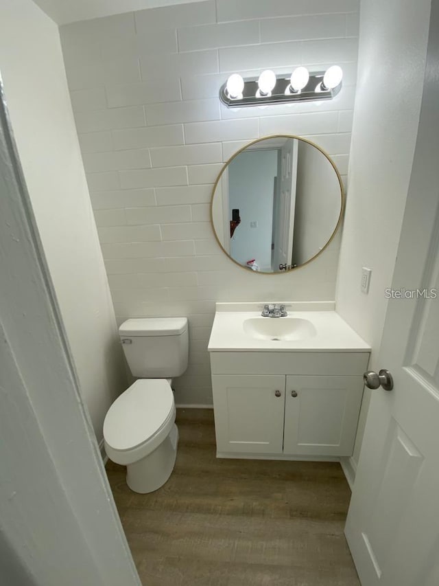 198 N Lake Ct, Kissimmee, FL 34743 - half bath with wood finished floors, vanity, toilet, and tile walls