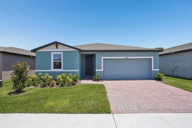 3214 Viceroy Ct, Kissimmee, FL 34759 - ranch-style house featuring decorative driveway, an attached garage, a front lawn, and stucco siding