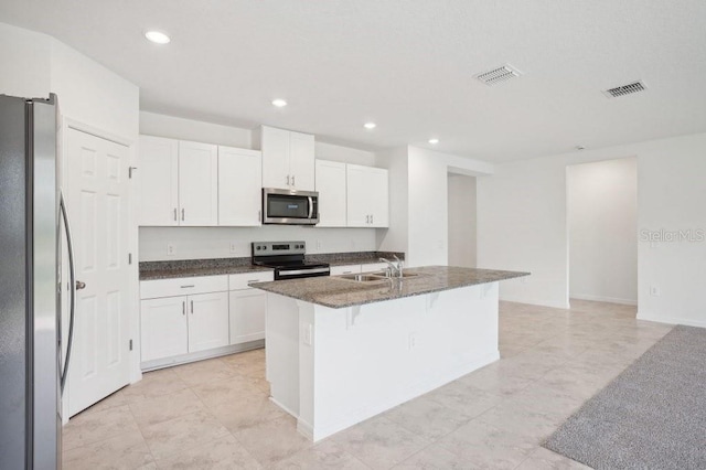 3214 Viceroy Ct, Kissimmee, FL 34759 - kitchen with stainless steel appliances, a sink, white cabinetry, a kitchen breakfast bar, and recessed lighting