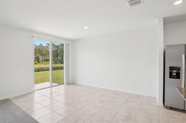3214 Viceroy Ct, Kissimmee, FL 34759 - empty room featuring recessed lighting, a water view, light tile patterned floors, a textured ceiling, and baseboards