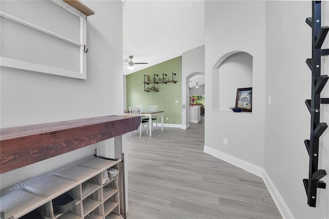 501 Dunoon St, Ocoee, FL 34761 - hallway featuring arched walkways, baseboards, light wood-style floors, and a towering ceiling