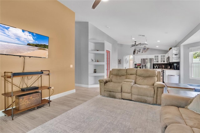 501 Dunoon St, Ocoee, FL 34761 - living room with light wood-style floors, built in shelves, ceiling fan, baseboards, and vaulted ceiling