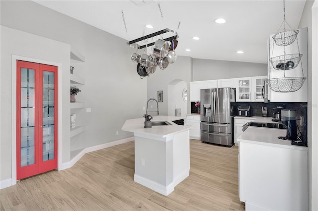 501 Dunoon St, Ocoee, FL 34761 - kitchen featuring appliances with stainless steel finishes, a sink, arched walkways, white cabinetry, and tasteful backsplash