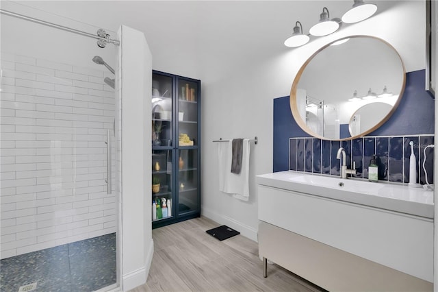 501 Dunoon St, Ocoee, FL 34761 - bathroom featuring a tile shower, vanity, wood finished floors, and baseboards