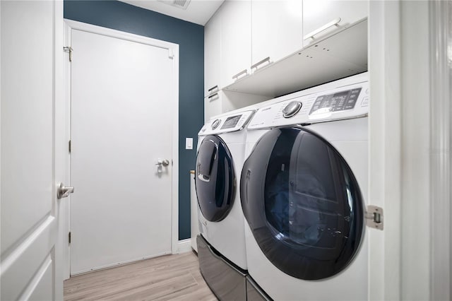 501 Dunoon St, Ocoee, FL 34761 - laundry room featuring cabinet space, washer and dryer, light wood-style floors, and baseboards