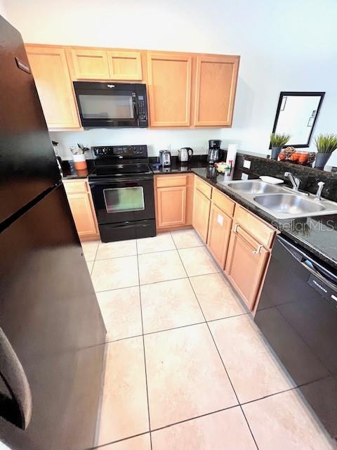 3014 Red Ginger Rd, Kissimmee, FL 34747 - kitchen with black appliances, a sink, light brown cabinetry, light tile patterned floors, and dark countertops