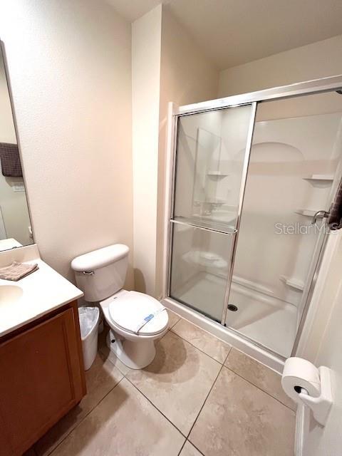 3014 Red Ginger Rd, Kissimmee, FL 34747 - full bathroom with vanity, a stall shower, toilet, and tile patterned flooring