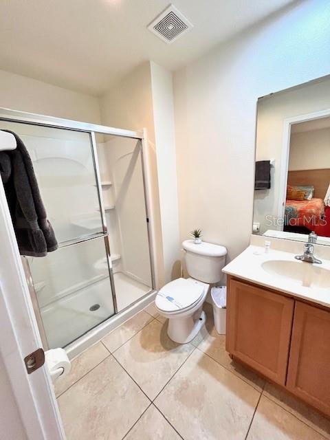 3014 Red Ginger Rd, Kissimmee, FL 34747 - bathroom featuring vanity, tile patterned flooring, a stall shower, and toilet
