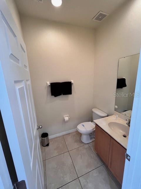 3014 Red Ginger Rd, Kissimmee, FL 34747 - bathroom featuring vanity, toilet, tile patterned floors, and baseboards