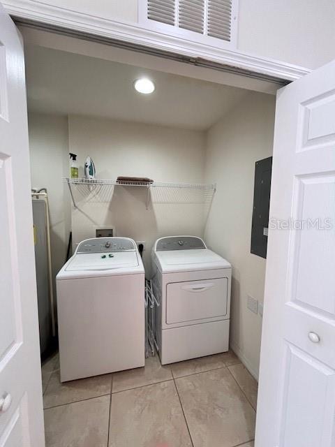 3014 Red Ginger Rd, Kissimmee, FL 34747 - laundry room featuring washer and dryer, electric panel, light tile patterned flooring, and recessed lighting