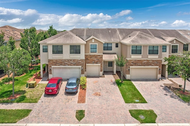 1628 Portofino Meadows Blvd, Orlando, FL 32824 - multi unit property featuring stucco siding, an attached garage, stone siding, and driveway