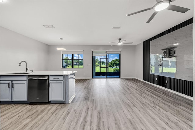 1628 Portofino Meadows Blvd, Orlando, FL 32824 - kitchen featuring dishwasher, a sink, light wood-type flooring, a ceiling fan, and open floor plan