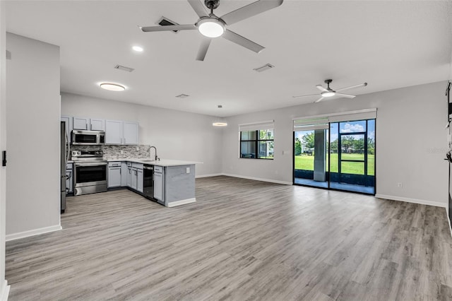 1628 Portofino Meadows Blvd, Orlando, FL 32824 - kitchen with appliances with stainless steel finishes, open floor plan, a sink, gray cabinetry, and ceiling fan