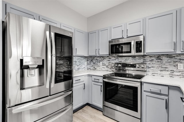 1628 Portofino Meadows Blvd, Orlando, FL 32824 - kitchen featuring stainless steel appliances, gray cabinetry, light countertops, and tasteful backsplash