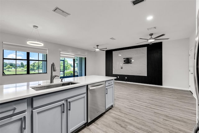 1628 Portofino Meadows Blvd, Orlando, FL 32824 - kitchen featuring dishwasher, a sink, a ceiling fan, light wood-style floors, and light countertops