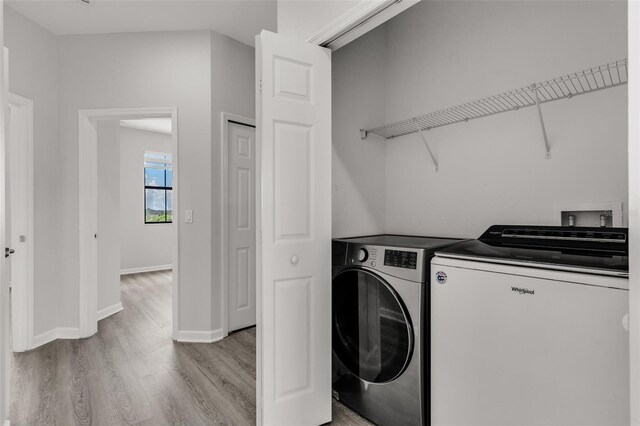 1628 Portofino Meadows Blvd, Orlando, FL 32824 - laundry area featuring washing machine and clothes dryer, light wood-type flooring, and baseboards